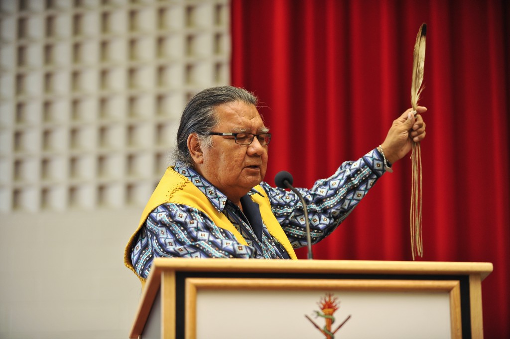eagle-feather Elder Walter Cooke performs an invocation at convocation on Oct. 13.